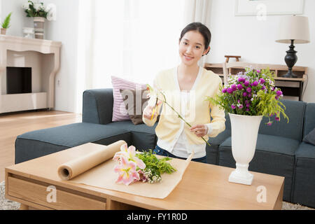 Young smiling woman making floral arrangements staring at front Stock Photo