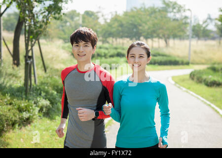 Couple in jogging outfits jogging together at the park Stock Photo
