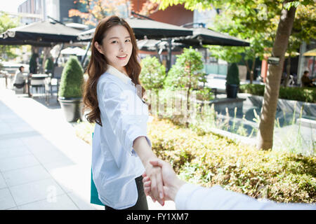 Woman pulling a hand of man outside Stock Photo