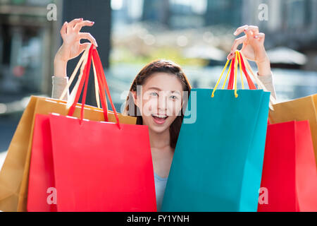 Woman holding many shopping bags and staring forward with a smile Stock Photo