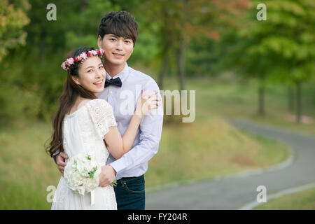 Bride and groom together at park in romance Stock Photo