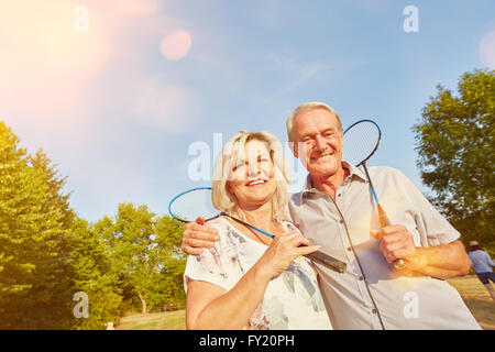 Happy senior couple while playing badminton in summer Stock Photo