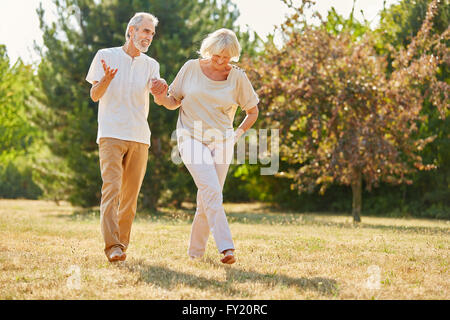 Couple in love holding hands on a walk in the park in summer Stock Photo