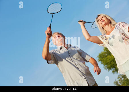 Happy senior couple playing badminton togheter as a team in summer Stock Photo