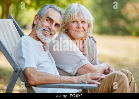 Senior man sitting on a deck chair with a fishing rod Stock Photo