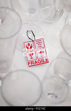 Fragile sign in red surrounded by glasses Stock Photo