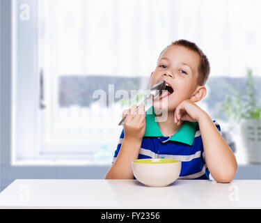 Little boy eating a healthy breakfast in the kitchen Stock Photo