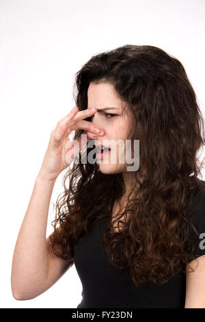 Woman pinches her nose in response to a stinky and smelly odor. Stock Photo