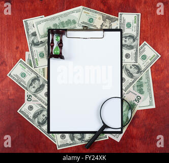 Blank paper sheet in clipboard placed on center of money dollar and wood background, coffee cup, business concept and informatio Stock Photo