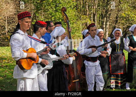 People playing folk instruments dresses in traditional costume on Plitvice lakes in Croatia Stock Photo
