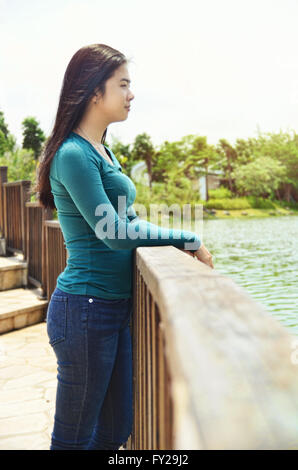 Portrait of Asian teenage girl standing by the lake Stock Photo