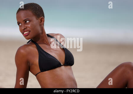 Woman in a bikini top sunbathing on the beach Stock Photo