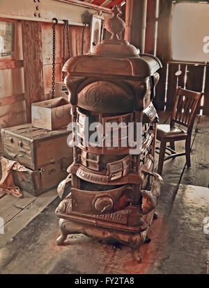 Vintage stove in abandoned barn in sepia colors  on wooden floor. Stock Photo