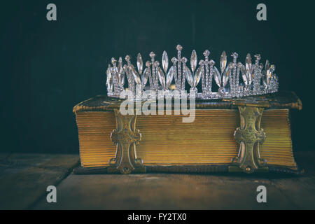 low key image of beautiful diamond queen crown on old book. vintage filtered. selective focus Stock Photo