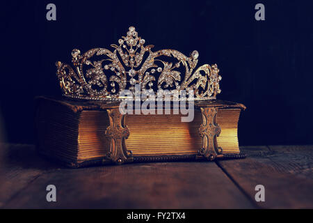 low key image of beautiful diamond queen crown on old book. vintage filtered. selective focus Stock Photo