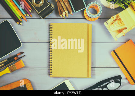 top view photo of blank notebook, old camera and school supplies on wooden table. vintage filtered Stock Photo