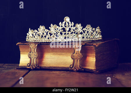 low key image of beautiful diamond queen crown on old book. vintage filtered. selective focus Stock Photo