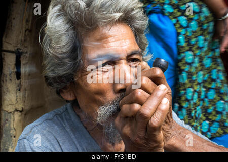 Local man smoking a joint on Shiva Day at Chitwan, Nepal. Marijuana or Cannabis is illegal in Nepal, but permitted as a religiou Stock Photo