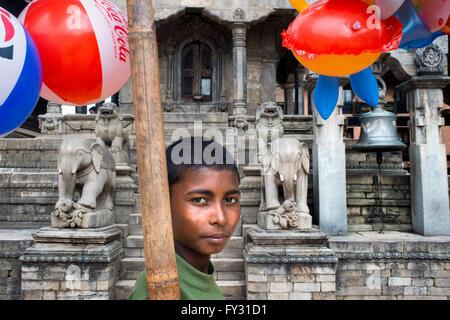 Local child selling balloms at Vatsala Durga Temple, Durbar Square, Bhaktapur, Nepal Stock Photo