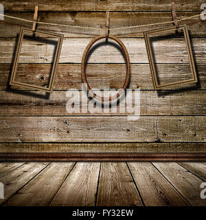 three picture frame hanging on clothespins on a background of of wooden wall Stock Photo