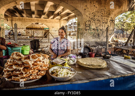 Woman cooks and sells street food in Yangon. Stock Photo