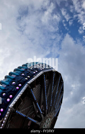 Ride turning in a fairground, cloudy sky on background Stock Photo