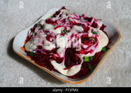 appetizing fresh vegetarian salad from young beet under sauce in plate
