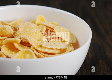 Corn flakes in small white bowls on a dark wooden background Stock Photo