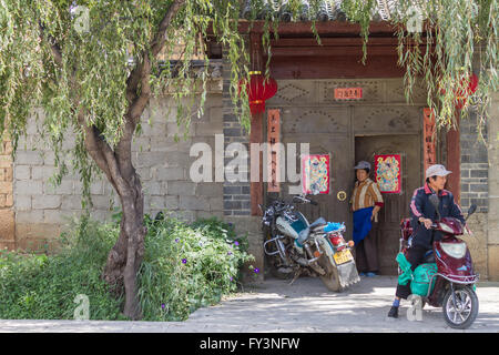 Lijiang, China: 2 people in front of traditional Chinese architecture Stock Photo