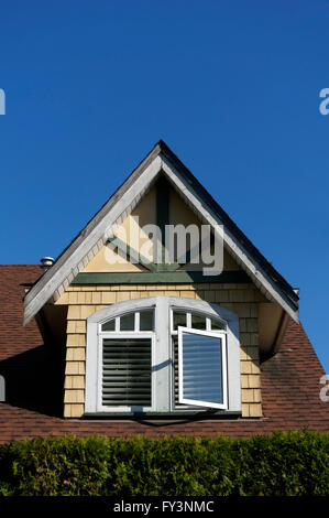 Old wooden dormer window in slate roof with leaded glass window panes