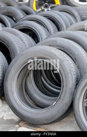 Pile of used rubber tyres in the garage shop. Stock Photo