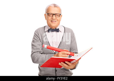 Cheerful mature teacher writing something in a notebook with a huge pencil isolated on white background Stock Photo