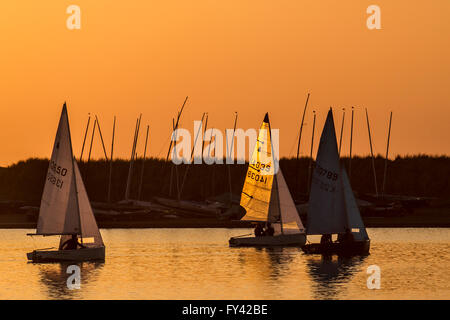 Yachtsman sailing dingy at sunset on Marine Lake. Southport, Marine Lake, Merseyside 20th April, 2016. UK Weather. Light Winds and a Golden Sunset over Marine Lake as 504 Ted James from Southport Sailing Club sails his RS Vareo yacht. The boat is a spinnaker powered single-hander. The stable hull, responsive rig and easy handling systems make the RS Vareo an attainable challenge in the right conditions- but not today. Stock Photo