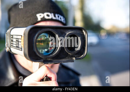Berlin, Germany. 21st Apr, 2016. A police officer looks through a speed scanner measuring the speed of passing by cars in Berlin, Germany, 21 April 2016. Police forces around Europe are conducting speed trap campaigns. Photo: Paul Zinken/dpa/Alamy Live News Stock Photo