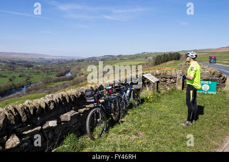 Teesdale, County Durham, UK.  21st April, UK Weather. Cyclist in the North Pennines enjoying the view along the River Tees at Whistle Crag near Middleton-in-Teesdale as the warm spring weather continues. Stock Photo