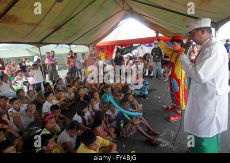 Portoviejo, Ecuador. 21st Apr, 2016. Cesar Macias (R), known as the clown 'Lapicito', cheers up the children that stay in a shelter installed after the earthquake at Tamarindos airport in Portoviejo, Ecuador, on April 21, 2016. Ecuador's Prosecutor's Office said in its latest report that the death toll of the devastating earthquake has reached 577. At least 13 foreigners from various countries were among the dead. (Xinhua/Rong Hao) Stock Photo