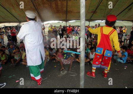 Portoviejo, Ecuador. 21st Apr, 2016. Cesar Macias (L), known as the clown 'Lapicito', cheers up the children that stay in a shelter installed after the earthquake at Tamarindos airport in Portoviejo, Ecuador, on April 21, 2016. Ecuador's Prosecutor's Office said in its latest report that the death toll of the devastating earthquake has reached 577. At least 13 foreigners from various countries were among the dead. (Xinhua/Rong Hao) Stock Photo