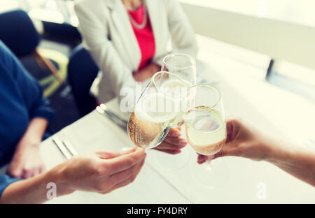 close up of women clinking champagne at restaurant Stock Photo