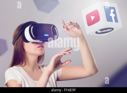 Varna, Bulgaria - March 10, 2016: Woman in VR headset looking up and interacting with Facebook Youtube Steam VR content. Stock Photo