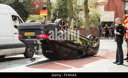 Car accident black Audi upside down with Police and Firemen looking on in disbelief Stock Photo