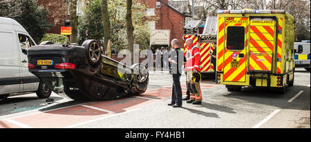 Black Audi car upside down, white transit, labour party banner, ambulance, policeman, firemen, fire engine, police van, bus Stock Photo