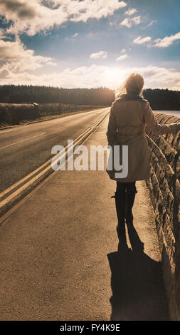 back view of the young woman standing on long bridge Stock Photo