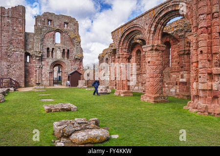 Visitor in the ruins of Lindisfarne Priory, Holy Island, Northumberland, England, UK Stock Photo