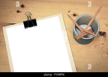Blank white paper on wooden table with pencils in holder Stock Photo