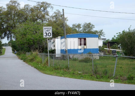 Old trailer home beside a rural highway with a 30mph speed limit sign. Loughman, Davenport, Florida, USA. 23rd April 2016 Stock Photo