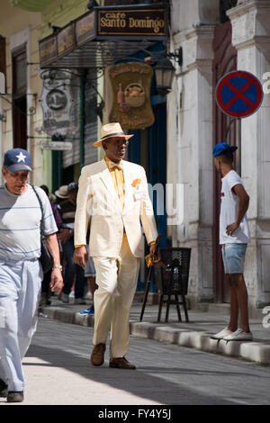 Vertical portrait of a smartly dressed man walking down the road in Havana, Cuba. Stock Photo