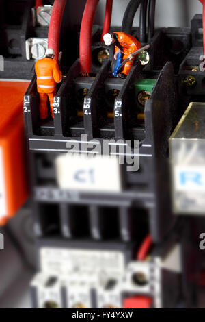 Miniature construction workers wiring electric circuit Stock Photo