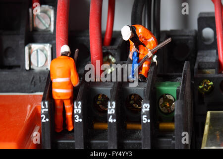 Miniature construction workers wiring electric circuit Stock Photo