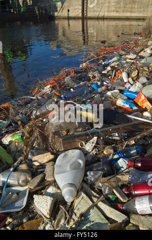 Plastic rubbish and other non-degradable waste in water of canal Stock Photo