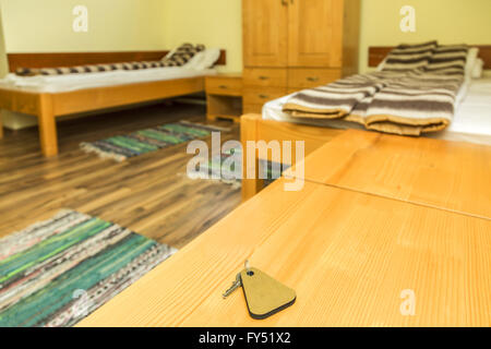 A key of a hotel room is on a wooden table. Selective focus. Stock Photo